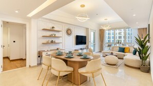 A modern living room with a sofa, a coffee table, and a dining area with a round table and chairs.
