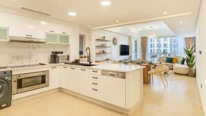 A modern kitchen with white cabinetry, a built-in oven, and a central island.