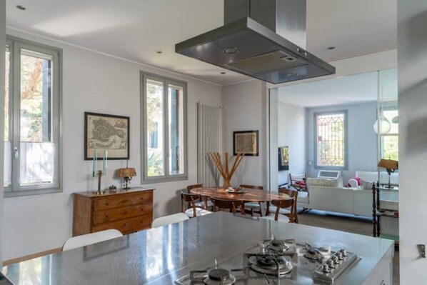 A modern kitchen with a large island, wooden cabinets, and a dining area with a table and chairs.