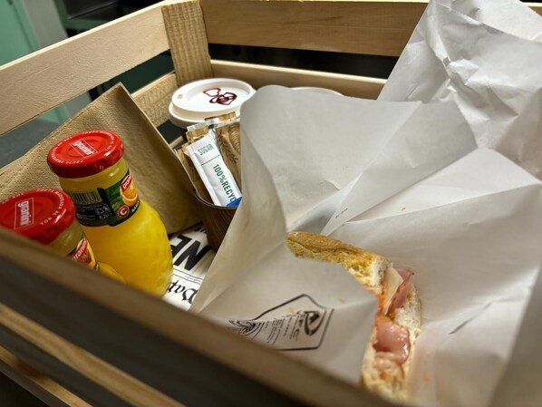 A wooden box containing a sandwich, a bottle of mustard, and a packet of sugar. - Aparthotel Terra Aurea (Salou)