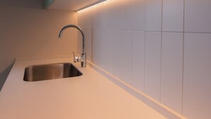 A modern kitchen with a stainless steel sink and a sleek faucet. - Aparthotel Terra Aurea (Salou)