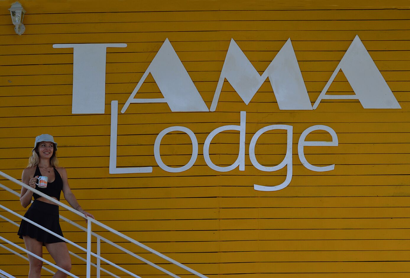 A yellow wall with the text "TAMA Lodge" in large white letters.