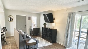 A modern bedroom with a sofa bed, a desk, a dresser, and a TV. - Mid city huntsvegas studio #2 (Huntsville)