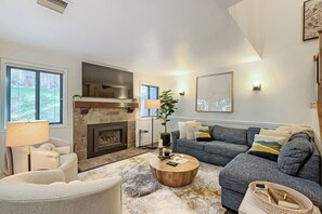 A living room with a fireplace, a sofa, a coffee table, and a lamp.