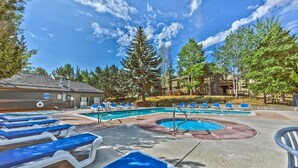 Un espace piscine avec des chaises longues et un jacuzzi.
