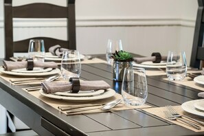 A dining table set with plates, glasses, cutlery, and napkins.