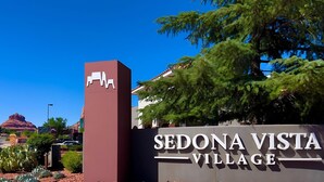 Señal de Sedona Vista Village, con cielo despejado y una montaña al fondo.