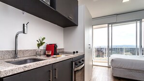 Una cocina moderna con horno empotrado, cafetera y lavamanos.
