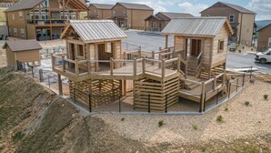 Una cabaña de estilo rústico con balcón y un espacio al aire libre cubierto.