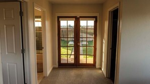 A hallway with a double door leading to a backyard. - NEW!  Charming Vineyard Cottage in the heart of the Russian river wine country! (Santa Rosa)
