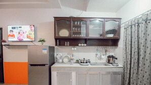 Eine kleine Küche mit einem Kühlschrank, einem Waschbecken und einem Schrank mit Glastüren.