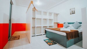 Ein Schlafzimmer mit einem Bett, einem Kleiderschrank und einer kleinen Sitzecke.