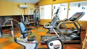 Un gimnasio con cintas de correr, máquinas de pesas y una prensa de banca.