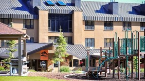 Un edificio moderno con un parque infantil, paneles solares en el techo y un cartel que dice "Cedar Falls".
