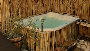 A hot tub surrounded by bamboo walls and rocks. - IL CAMPO Ecolodge & Boutique Hotel (Giza)