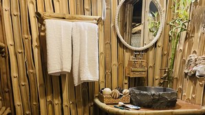A bamboo-themed bathroom with a toilet, sink, and mirror. - IL CAMPO Ecolodge & Boutique Hotel (Giza)