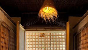 A traditional Japanese interior with a tatami mat entrance, a hanging chair with green cushions, and a bamboo screen. - IL CAMPO Ecolodge & Boutique Hotel (Giza)