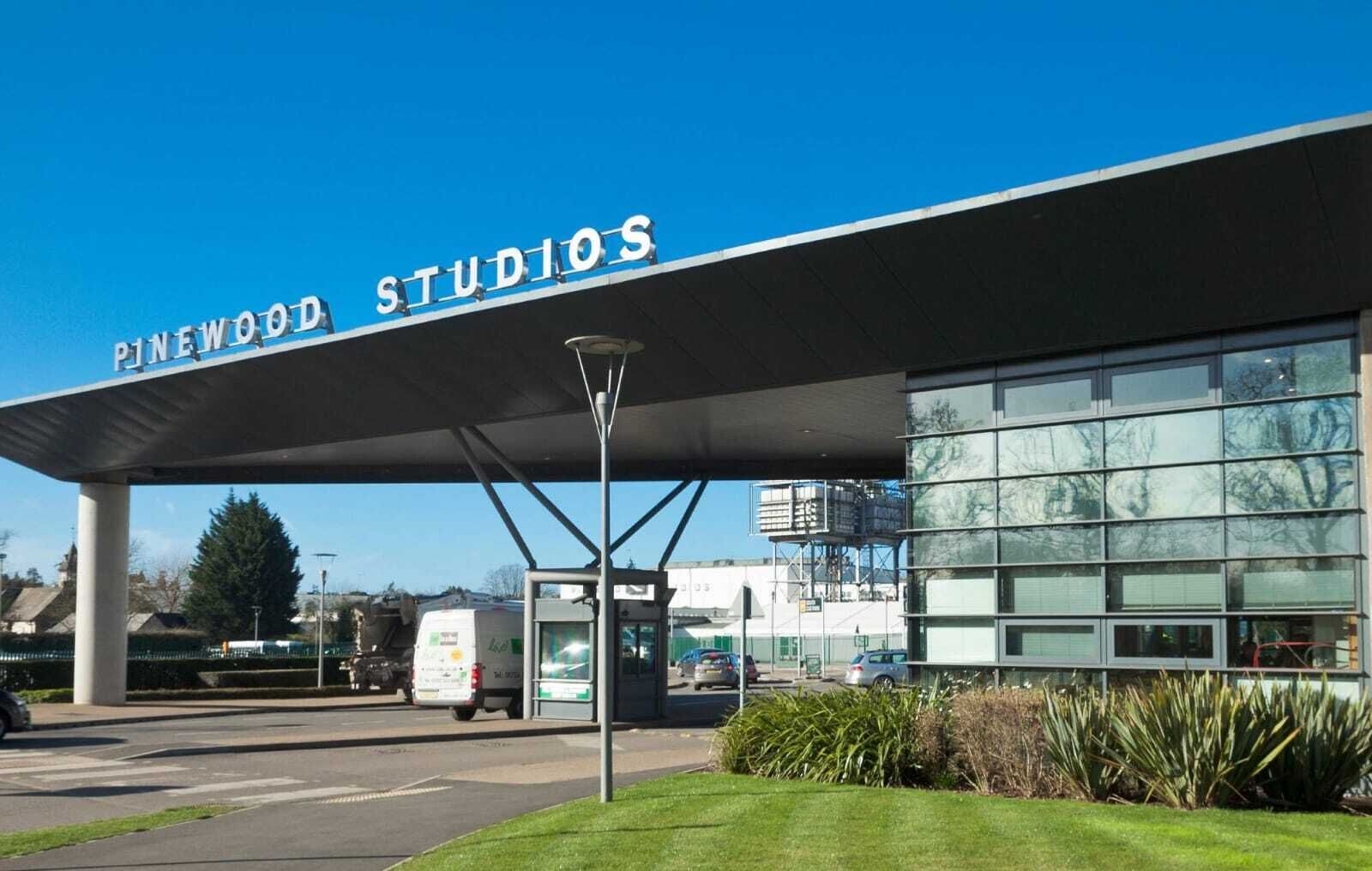 A building with a sign that reads 'Pinewood Studios' and a covered entrance.