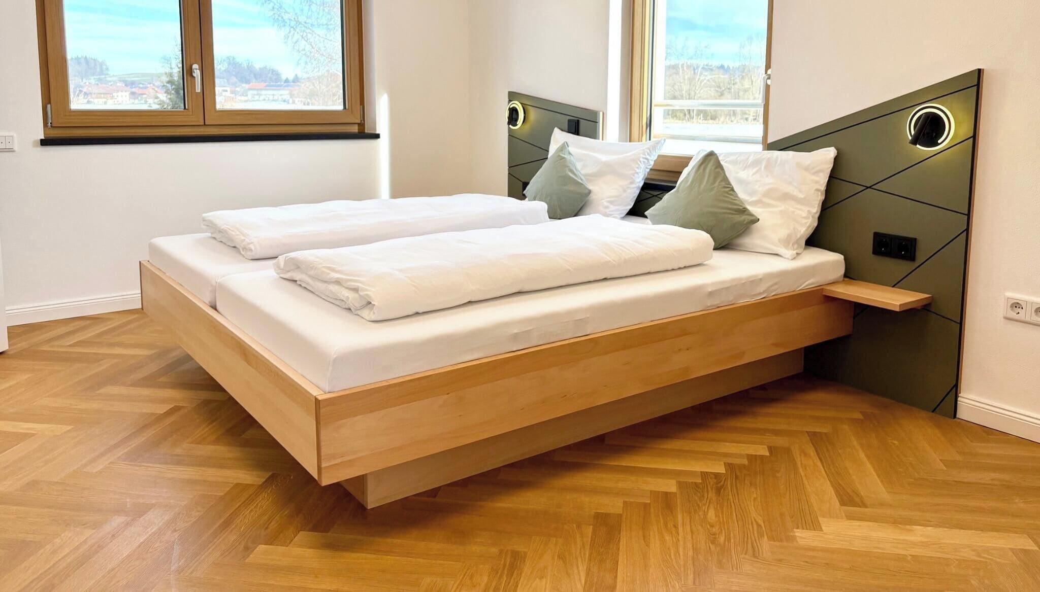 Una cama moderna con estructura de madera, ropa de cama blanca y cabecera con luces circulares.