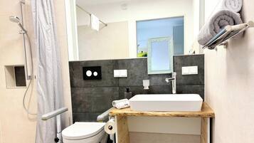 Ein modernes Badezimmer mit Dusche, Toilette und Waschbecken.