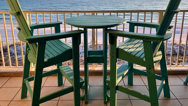 Une vue sur l’océan depuis un balcon agrémenté d’une table et de chaises.