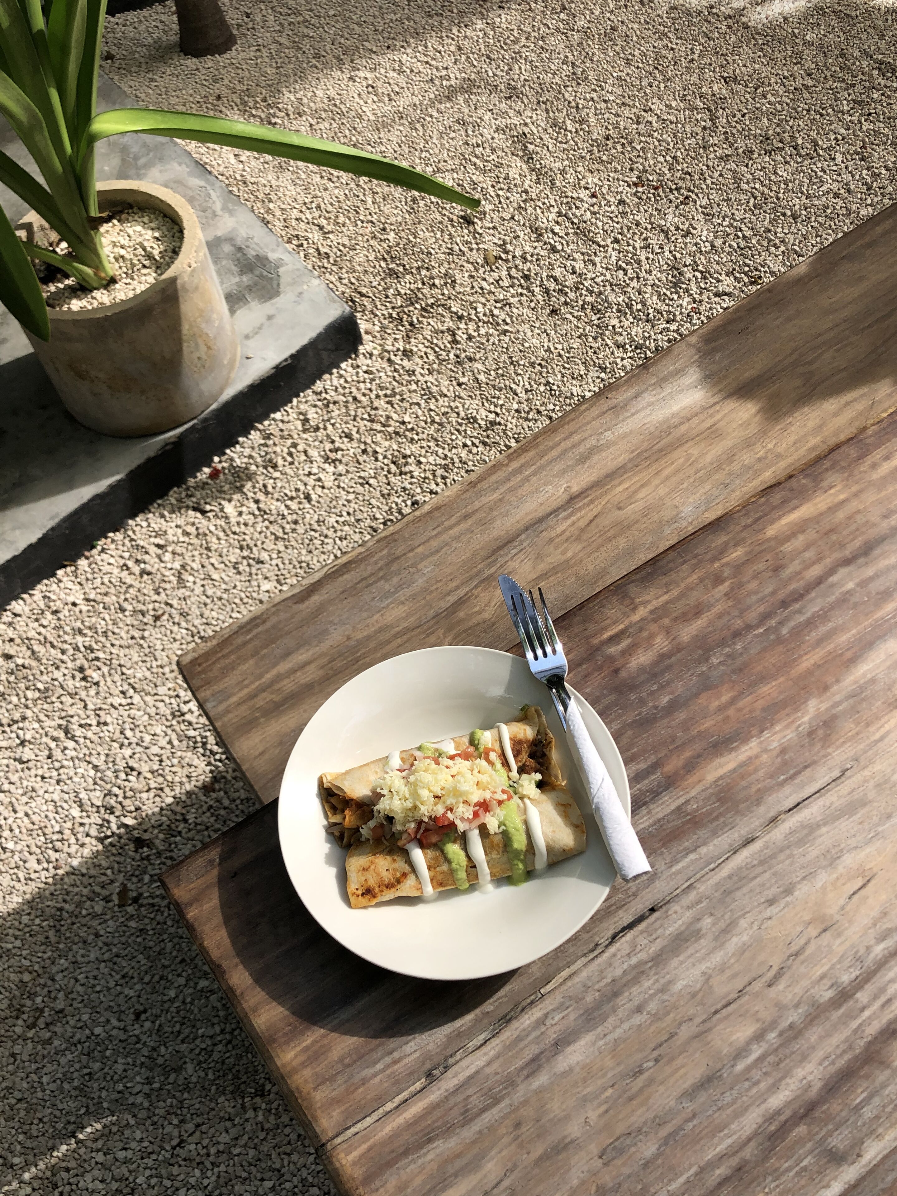 Une table en bois avec une assiette de nourriture et une fourchette.