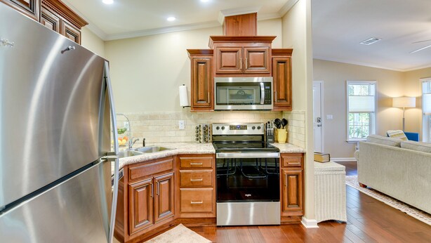 A modern kitchen with stainless steel appliances, wooden cabinets, and a built-in microwave. - ‘The Hammock Cottage’ w/ Fire Pit < 1 Mi to Beach! (Palm Coast)