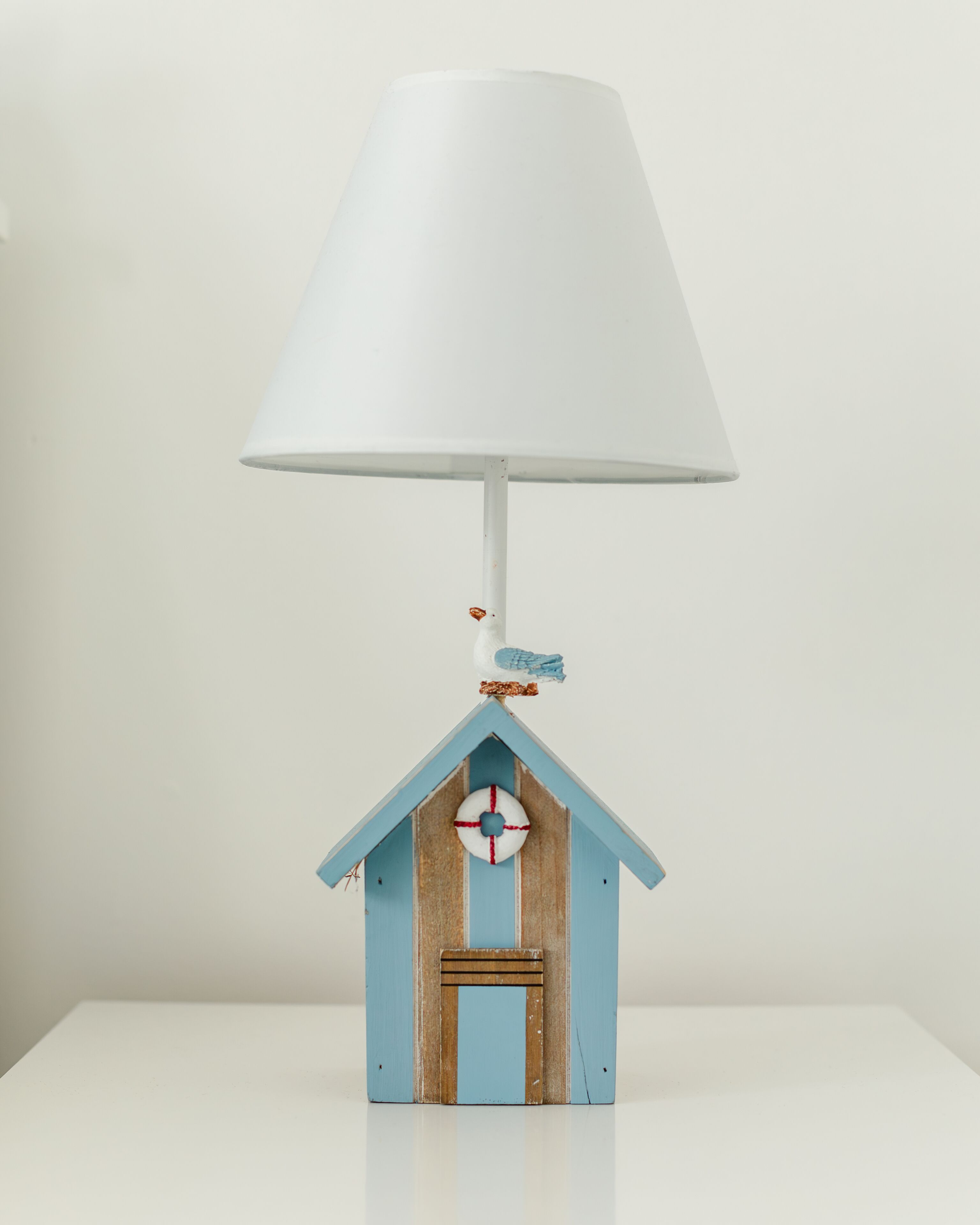 A small wooden house with a white lamp on top.