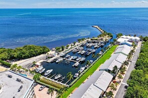 An aerial view of a marina with boats docked, a marina building, and a road leading to the marina. - Key Largo Townhouse Next to Pool and Salt Water Lagoon in Gated complex (Key Largo)