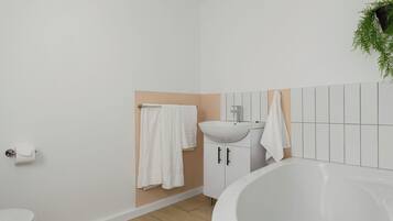Een badkamer met toilet, wastafel en bad.