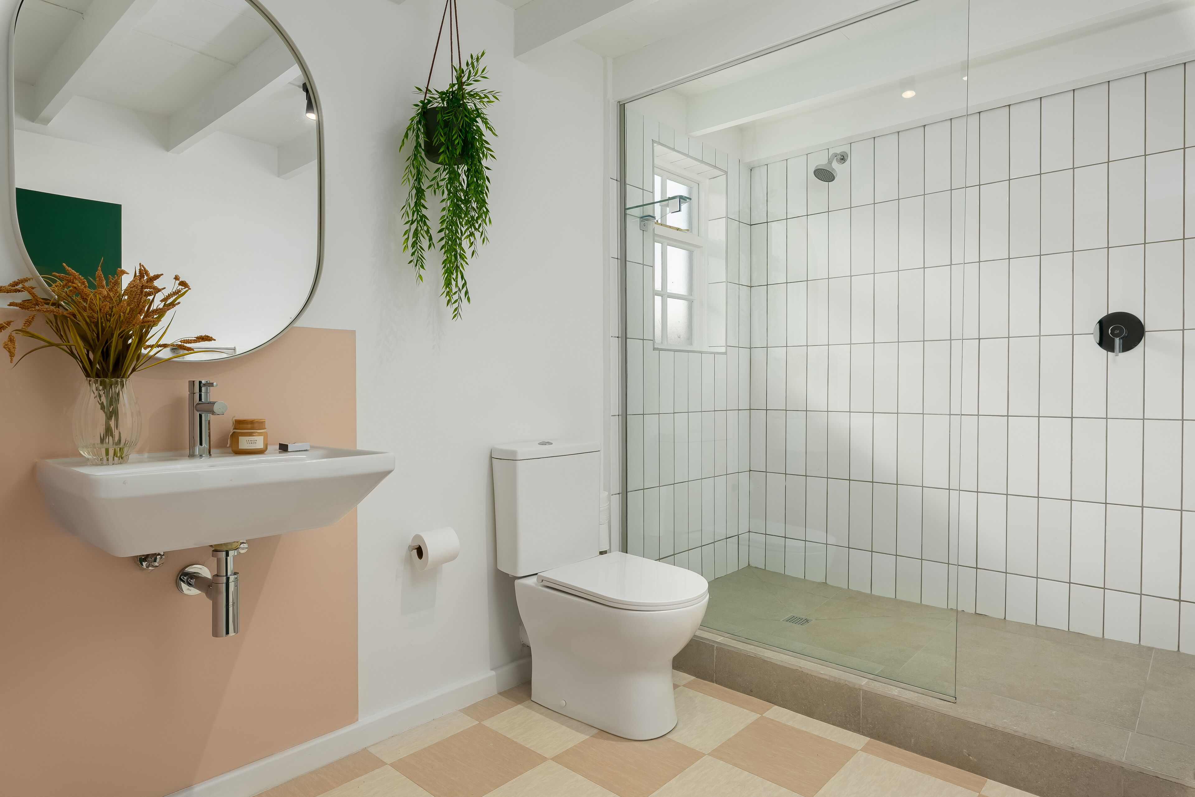 A modern bathroom with a white sink, toilet, and glass shower enclosure.