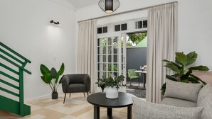 A modern living room with a sofa, a round table, and a potted plant. - Neighbourgood Franschhoek (Franschhoek)
