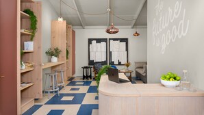 A modern reception area with a wooden desk, a bowl of green apples, and a wall with motivational writing. - Neighbourgood Franschhoek (Franschhoek)