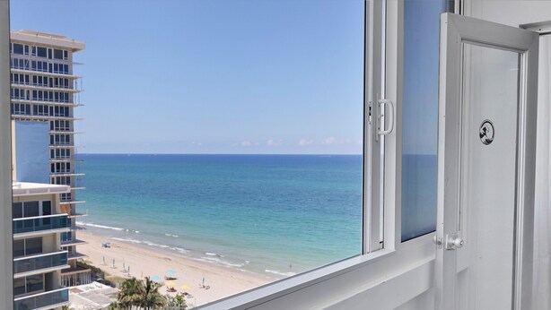 A view of a beach from a hotel room with a clear sky.