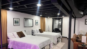 A hotel room with two beds, a desk, a chair, and a small table with a lamp. - Flagship Park - 10 Mins to Everything! (Kansas City)