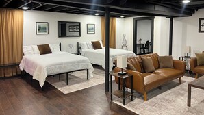 A hotel room with two beds, a leather sofa, a small table, and a desk with a chair. - Flagship Park - 10 Mins to Everything! (Kansas City)