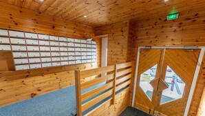 Un intérieur en bois avec un escalier menant à une porte, une moquette bleue et un mur avec des étagères.
