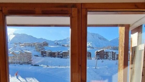 A wooden door with a view of a snowy landscape and buildings. - Ski-in/ski-out & foot of the slopes, 6th floor, balcony, tv, ski locker, 25m², La Plagne (La Plagne)