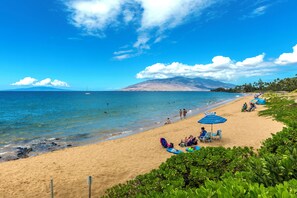 Una playa cerca, sillas reclinables de playa, toallas de playa