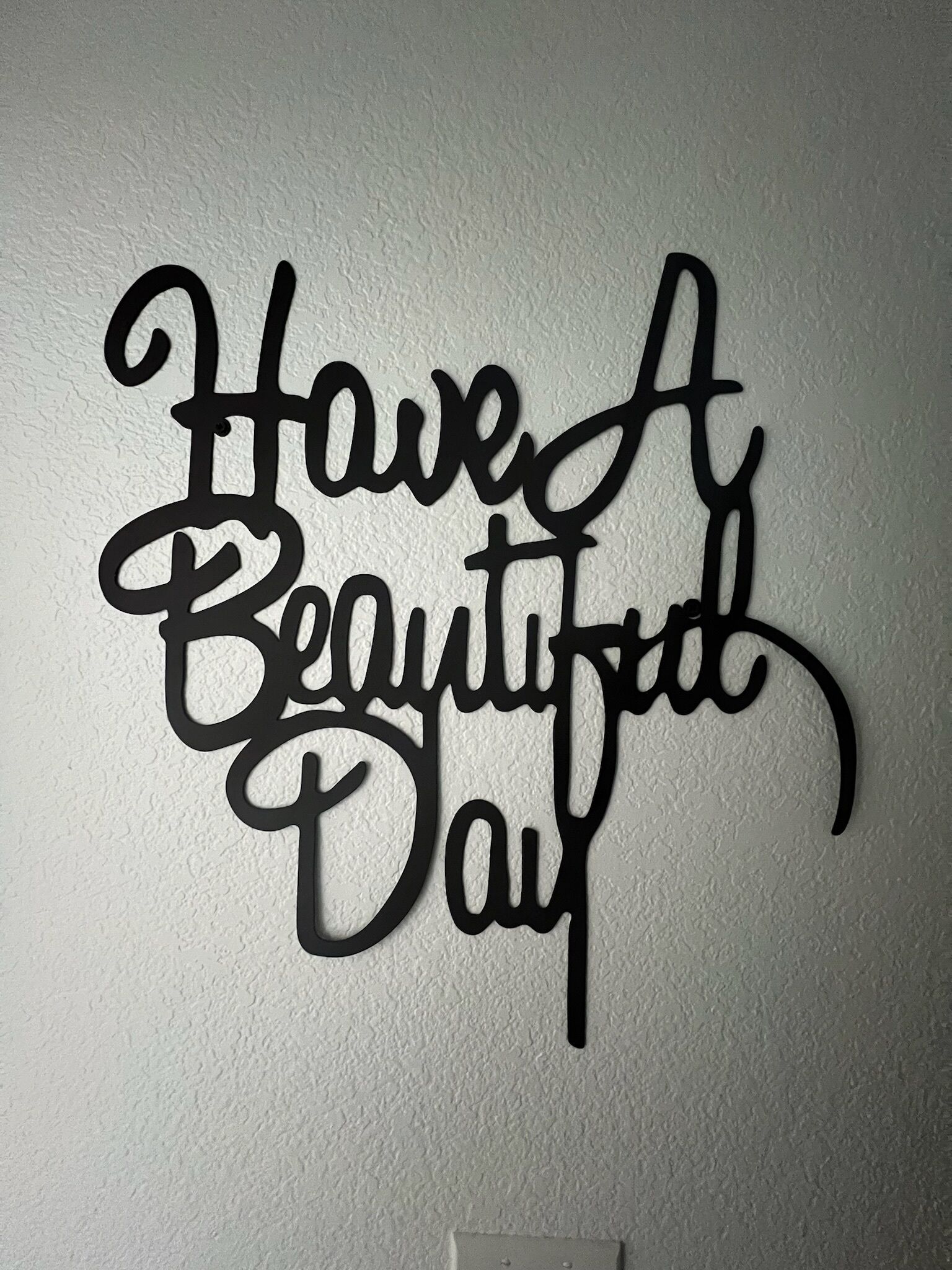 Paret amb un cartell decoratiu que diu "Passa un bon dia."