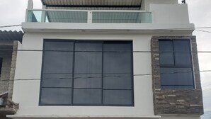 Uma casa moderna de dois andares com uma garagem espaçosa, uma varanda e uma parede de destaque em pedra.