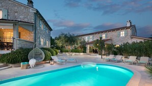 A stone building with a swimming pool, outdoor seating, and a well-maintained garden. - Villa Pietrissima with Pool (Kanfanar)