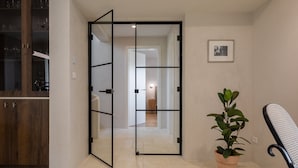 A hallway with a mirrored door leading to a room, a potted plant, and a framed picture on the wall. - Villa Oasi di Sogno with Pool (Biograd na Moru)