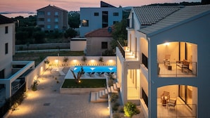 A modern residential complex with a swimming pool, outdoor seating, and multiple balconies. - Villa Oasi di Sogno with Pool (Biograd na Moru)