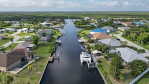 A residential area with houses, a canal, and a boat docked at a pier.