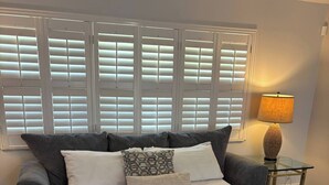 A bedroom with a large bed, a grey sofa, a lamp, and a mirror. - Heated Pool Oasis - Sleeps 12 (Port St. Lucie)
