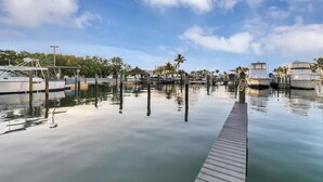 Un port de plaisance avec des bateaux amarrés, une eau calme et un quai en bois.