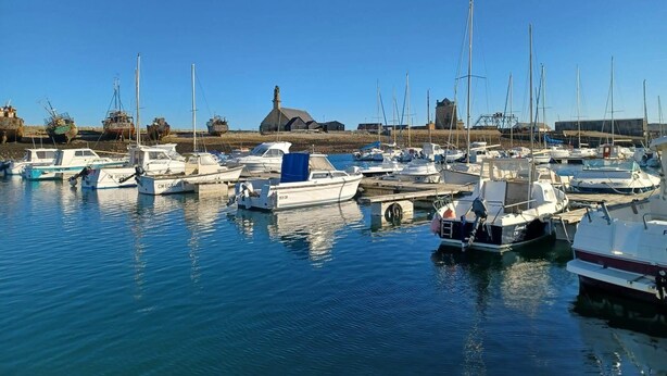A marina with various boats docked, a building in the background, and calm water. - Maison Plein Pied a Loué a Camaret sur mer (Camaret-sur-Mer)