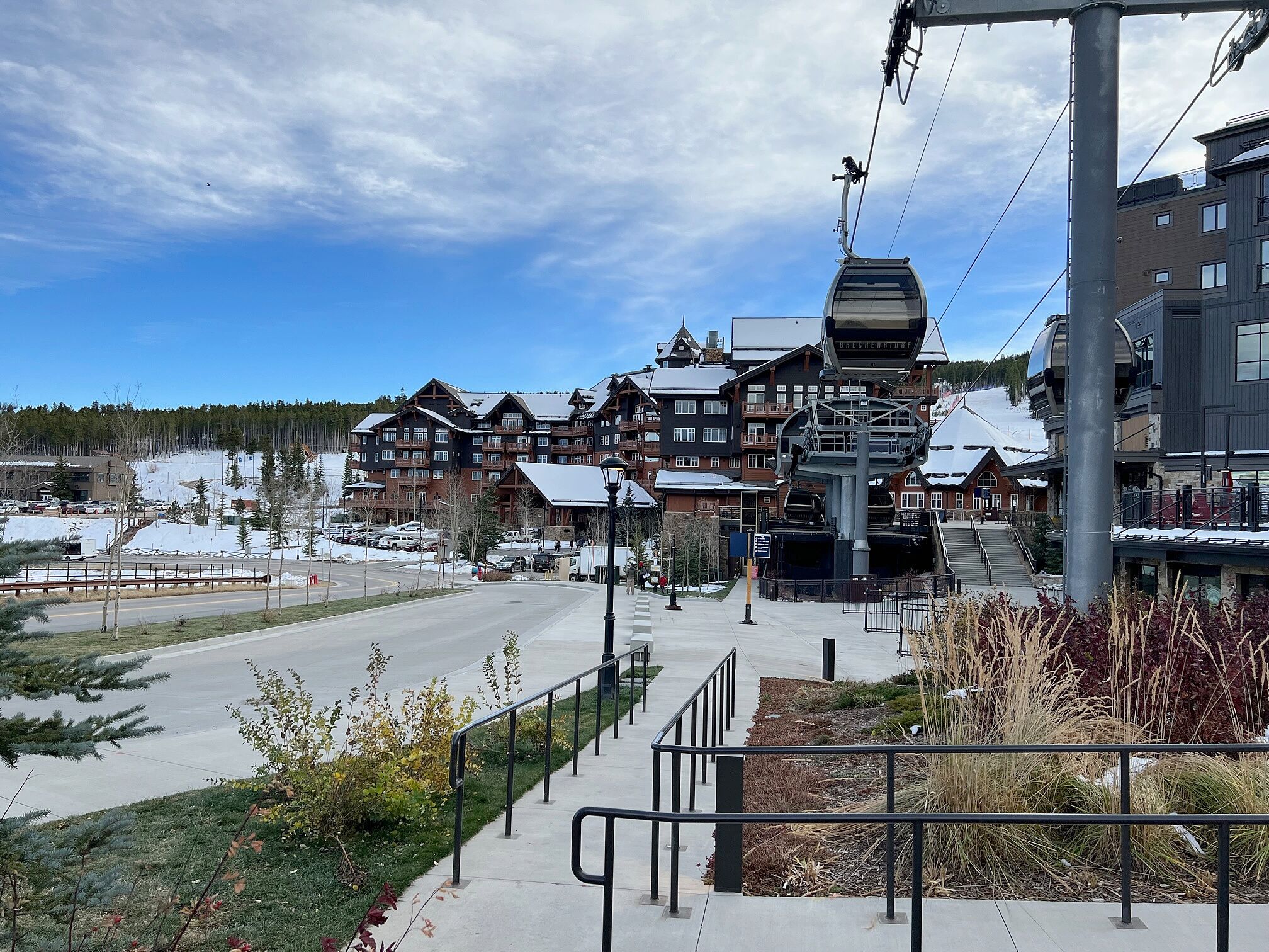 A ski resort with a cable car system, wooden buildings, and a clear sky.
