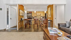 A modern kitchen with wooden cabinets, a dining area with chairs, and a living room with a couch. - BEST VALUE three bedroom in prime Peak 8 location (Breckenridge)